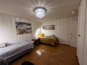 泰比Stockholm stort Rum - Dator Arbetsplats Gratis Wifi 1Gb Fiber Parkering Garderober Room2的一间卧室配有两张床和吊灯。