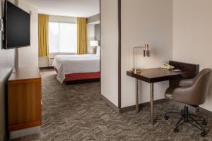 波特兰波特兰机场春季山丘套房酒店的酒店客房配有一张床、一张书桌和一台电视。