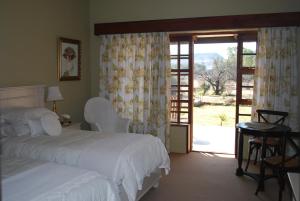 布隆方丹橄榄山乡村旅馆的一间卧室设有两张床和滑动玻璃门