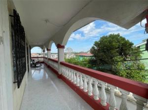 圣伊格纳西奥Arnold's Guest House的阳台设有红色和白色栏杆,享有风景。