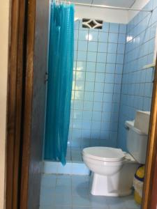 卡维塔rooms megi terminal的浴室设有卫生间和蓝色的浴帘。
