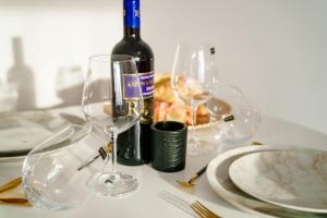 克拉约瓦Studio Lounge的一张桌子,上面放着一瓶葡萄酒和两杯酒杯