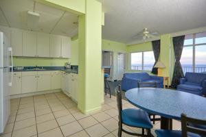 巴拿马城海滩Palmetto Beachfront Hotel, a By The Sea Resort的厨房以及带桌椅的用餐室。