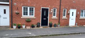 BuckinghamshireAylesbury Lovely Double and Single Bedroom with Guest only Bathroom的门前有盆栽植物的砖房