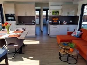 佩讷明德Hausboot Marama - LP10的厨房以及带橙色沙发的起居室。
