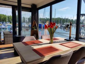 佩讷明德Hausboot Marama - LP10的海港房顶上带花瓶的桌子