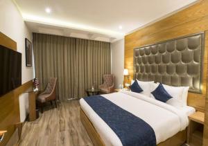 新德里Hotel Seven Inn (R S Gorup Near Delhi Airport)的酒店客房设有一张大床和一张书桌。