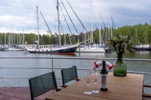 佩讷明德Hausboot LP1的一张带两杯酒和一瓶葡萄酒的木桌