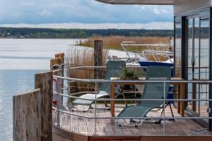 佩讷明德Hausboot LP1的一个带椅子和桌子的码头和一条船