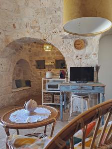 弗兰卡维拉丰塔纳Residenza Anima Mediterranea的客厅配有桌子和石墙