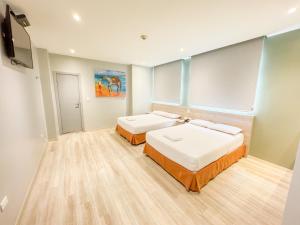 瓜亚基尔GH Sander Hotel的客房设有两张床和一台平面电视。