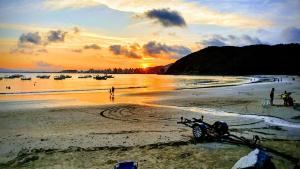 佩尼亚Cabanas São Miguel的日落时在海滩上躺着的摩托车