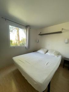 拉罗克当泰龙Vacances en Provence en mobil home的窗户客房内的一张白色床