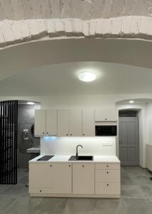 兹诺伊莫Pension Phoenix的厨房配有白色橱柜和水槽
