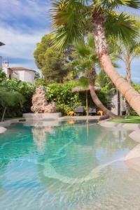 哈维亚Hotel Casa Lili的度假村内棕榈树游泳池