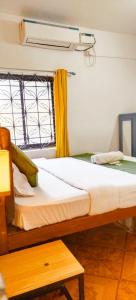 巴加Baga Beach Paradise的窗户和床筒的房间里一张床位
