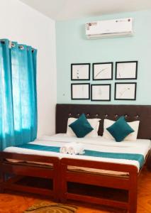 巴加Baga Beach Paradise的蓝色窗帘的房间的一张床位