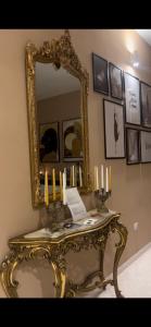 萨莱诺TIZIANA'S HOUSE的墙上的镜子,带蜡烛的桌子