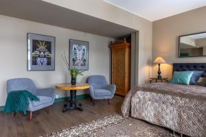 胡迪克斯瓦尔White Brig Guesthouse的一间卧室配有一张床、两把椅子和一张桌子