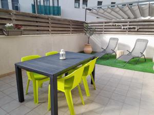 埃斯塔蒂特Apartamento Lliris Sol的天井配有桌子和黄色椅子