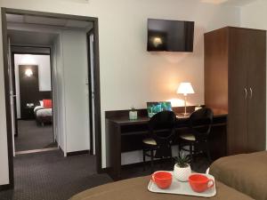 卢尔德联盟酒店的酒店客房设有书桌和卧室。