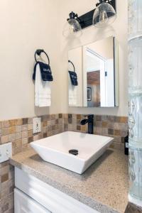 沃尔卡诺Hale Ho'okipa的浴室设有白色水槽和镜子