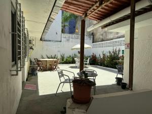 累西腓Casa Recife Pousada的庭院配有桌椅和遮阳伞。