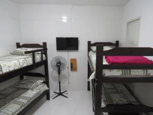 瓜鲁柳斯Hostel Brasil Gru的客房设有三张双层床和一台平面电视。