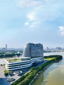 广州洲至奢选广州香岚官洲酒店的一座大建筑,毗邻一条有城市的河流