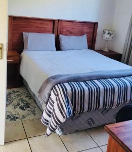 姆巴巴内African Violet的一间卧室配有一张大床和木制床头板