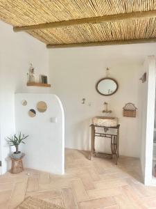 PechãoLa Quinta da Liberdade - Ferme de charme en Algarve的墙上设有桌子和镜子的房间