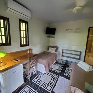 阿布拉奥Casa Araribá - Ilha Grande的客房设有一张床、一张桌子和一张桌子。