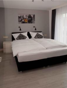 赞德沃特施尔维斯公寓的一间卧室配有一张带白色床单的大床
