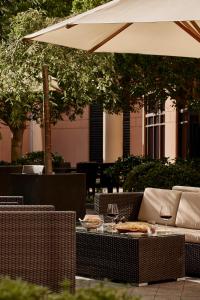 墨尔本墨尔本柏悦酒店的户外庭院配有桌椅和遮阳伞。