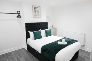 利物浦Modern & Spacious, Central Location, FREE PARKING, FREE WIFI的一间卧室配有一张带绿色和白色枕头的大床