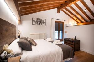 ArráyozCasa Rural Kabia的卧室设有白色大床和木制天花板。