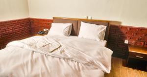雅温得KC GuestHouse的一张带白色床单和枕头的床