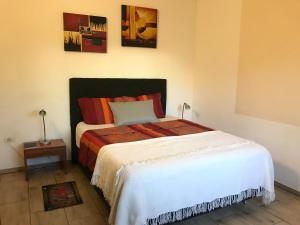 卡库佩Casa Loro的一间卧室配有一张带白色床罩的床