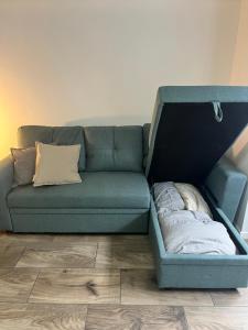 布里斯班Pavillion on Brookes的蓝色的沙发,床在房间中间