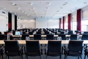 奥尔堡东奥尔堡斯堪迪克酒店的一间空的讲座室,配有桌椅