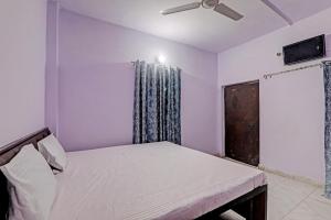 勒克瑙Gracious Guest House的一间卧室设有一张床和一个窗口