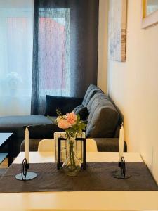 谢莱夫特奥Noah Longstay Skellefteå的客厅配有沙发和花瓶(桌子上)