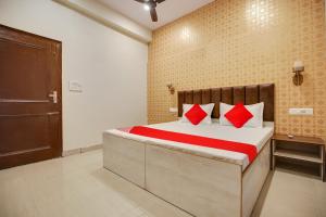 卢迪亚纳Super OYO Hotel Sky Orchid的一间卧室配有一张带红色枕头的床