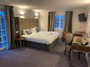 达灵顿The George - Sure Hotel Collection by Best Western的酒店客房带一张大床和一把椅子
