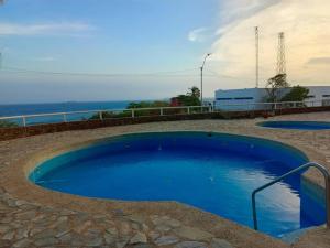 PampatarPlaya dorada的一个蓝色的大型游泳池,背景是大海