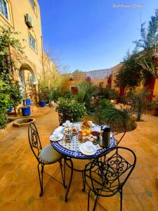 扎古拉Riad Fennec Sahara的庭院里摆放着桌椅和食物