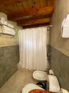 拉安戈斯图拉镇Cabañas Rukayen的浴室配有白色的浴帘和卫生间