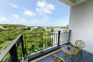 小琉球岛小琉球海明珠渡假旅店的设有一个配有桌椅并享有美景的阳台。