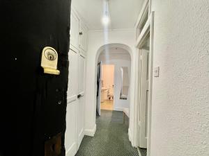 珀利Cozy One Bed Apartment Near Purley Station的白色墙上的带时钟的走廊