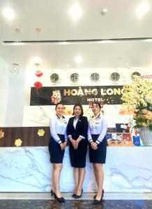 潘切Hoang Long Hotel Phan Thiết的站在标志前的三个妇女团体